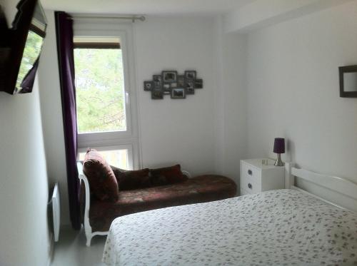 ein Schlafzimmer mit einem Bett, einem Sofa und einem Fenster in der Unterkunft LE BELVEDERE 1- Front de Mer - Plage Argelès in Argelès-sur-Mer
