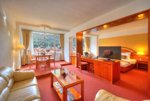 a living room filled with furniture and a large window at Hotel Aro Palace in Braşov