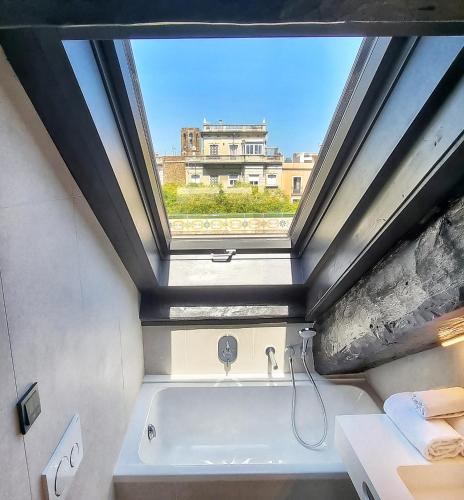 a bathroom with a bath tub with a window at Hotel Sant Agustí in Barcelona