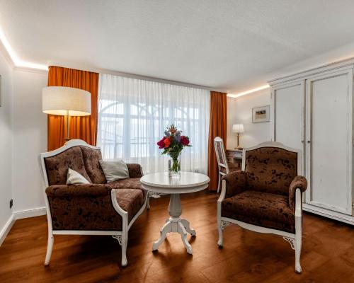 a living room with a couch and a table and two chairs at Villa Salve in Binz