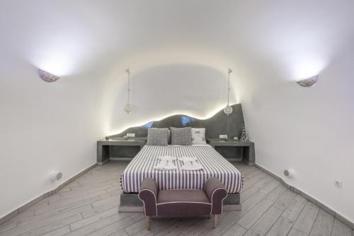 une chambre blanche avec un lit et une chaise dans l'établissement Fira-Cave-Sleeps 13-Parking-Pool-Pet Friendly, à Fira