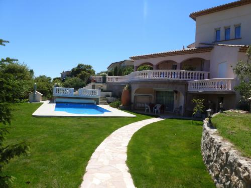 uma casa grande com um quintal com piscina em Appartement du Lac em Les Esterets du Lac