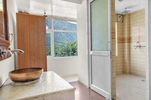 La salle de bains est pourvue d'un lavabo, d'une douche et d'une fenêtre. dans l'établissement Sparsh Resort, à Manali