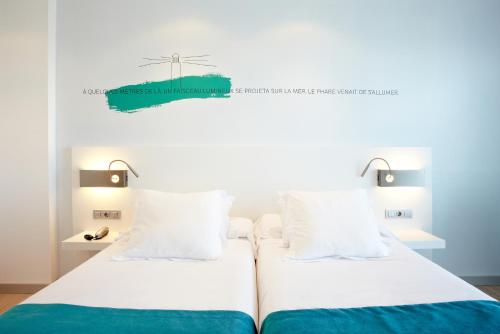 a bedroom with two beds and a windmill on the wall at Hotel Costa Azul in Palma de Mallorca