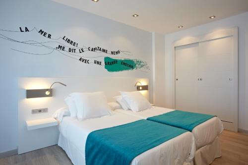 a bedroom with a bed with words on the wall at Hotel Costa Azul in Palma de Mallorca