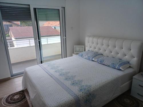 a bedroom with a bed and a large window at Villa Elina Ulcinj Montenegro in Donji Štoj