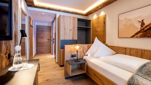 a hotel room with a bed and a table at Hotel Almhof in Galtür