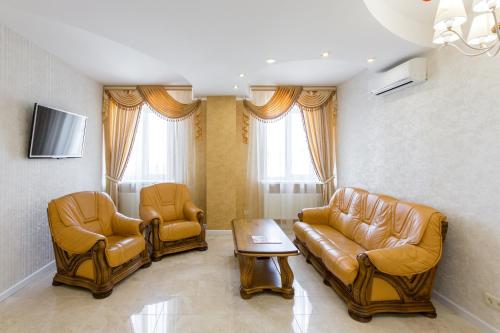 a living room with couches and chairs and a tv at Hotel Premier in Kamianske