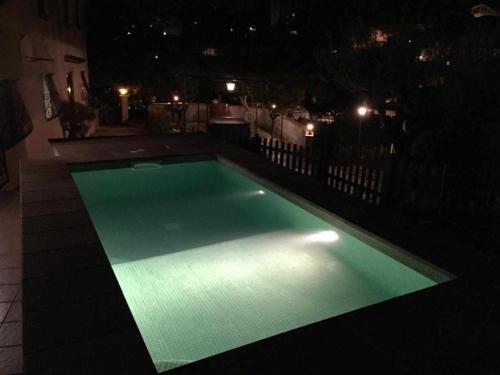 a swimming pool lit up at night on a balcony at Masía Can Tramontana in Tiana