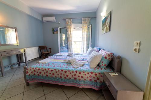 a bedroom with a bed and a table in it at Lambrini Studios in Parga