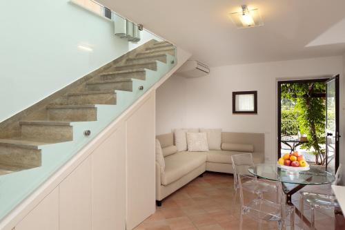 a staircase in a living room with a couch and a glass table at Giotto Country House & Spa in Assisi