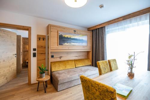 een kamer met een tafel en stoelen en een bed bij Apartment Bergsee in Lunz am See