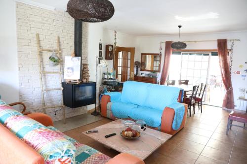 a living room with a blue couch and a table at Casa da Avó Bela in Buarcos