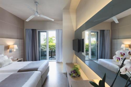 a hotel room with two beds and a tv at Acharavi Beach Hotel in Acharavi