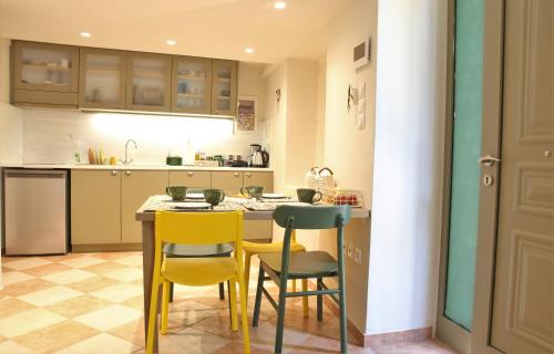 a kitchen with yellow chairs and a table at For4 Seasons Home 2 - by Avelink in Spáta