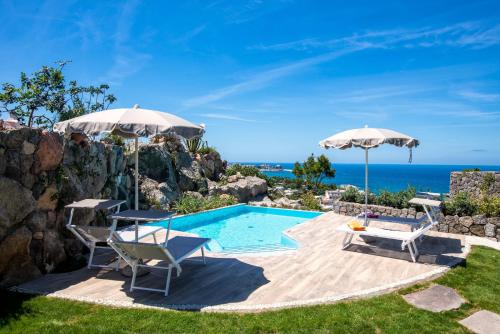 a pool with two chairs and two umbrellas at Villa dei Lecci - 7 Luxury villas with private pool or jacuzzi in Ischia