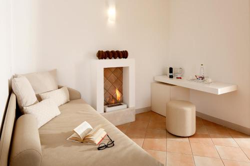 a living room with a couch and a fireplace at Giotto Country House & Spa in Assisi