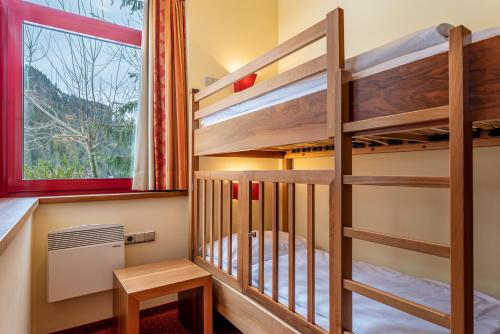 a bunk bed room with bunk beds and a window at Hotel Tyrol am Haldensee in Haldensee
