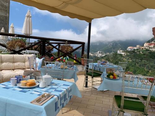 a patio area with tables, chairs and umbrellas at Nonno Francesco B&B in Ravello