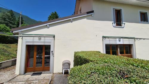 une maison blanche avec une chaise en face dans l'établissement Residence de la Plage, au Bourget-du-Lac