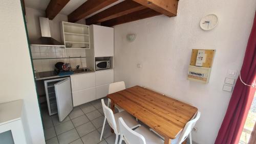 Il comprend une petite cuisine avec une table et des chaises en bois. dans l'établissement Residence de la Plage, au Bourget-du-Lac