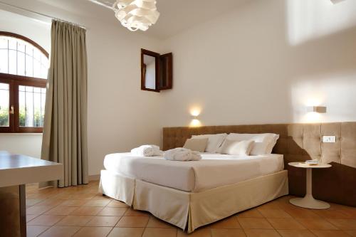 a bedroom with a large white bed in a room at Giotto Country House & Spa in Assisi