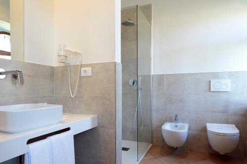 a bathroom with a sink and a toilet and a shower at Giotto Country House & Spa in Assisi