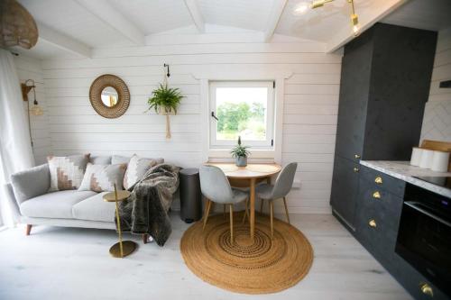 a living room with a couch and a table at The Paddocks Cabin - Stylish, Cozy & Private in Killarney