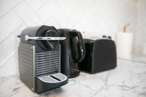 a kitchen counter with three black appliances on it at The Paddocks Cabin - Stylish, Cozy & Private in Killarney