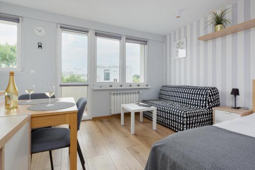 een slaapkamer met een bed, een tafel en een bank bij Apartments City Center Powiśle in Warschau