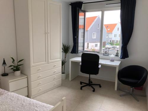 um quarto com uma secretária, 2 cadeiras e uma janela em B&B Twiske Zuid, Amsterdam free parking em Amesterdão