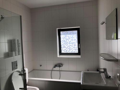 La salle de bains est pourvue d'une baignoire, d'un lavabo et d'une fenêtre. dans l'établissement B&B Twiske Zuid, Amsterdam free parking, à Amsterdam