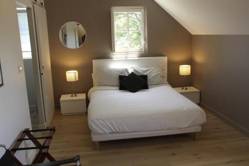 L'Audacieuse في Behuard: غرفة نوم بسرير وملاءات بيضاء ونافذة