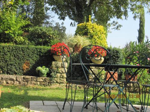 a bench with red flowers on it in a garden at le vieux pont in Carpentras