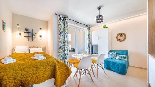 a bedroom with a bed and a table and chairs at Klifowa Rewal, Sun & Snow in Rewal