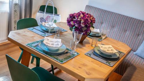 a wooden table with plates and bowls and flowers on it at Auszeit Aussee in Bad Aussee