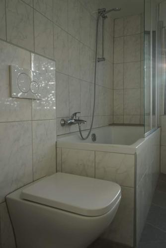 La salle de bains est pourvue d'une douche, de toilettes et d'une baignoire. dans l'établissement Gästewohnung Holzheim, à Pohlheim