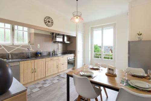une cuisine avec une table et des chaises en bois ainsi qu'une salle à manger dans l'établissement L'appartement à Cardaillac, à Rodez