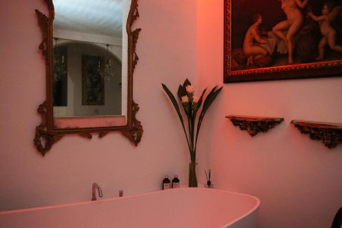 a pink bathroom with a tub and a mirror at Domus Socolatae Residenza d'Epoca Charming B&B - Adults Only in Follonica