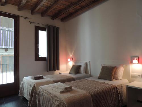 Casa Rural Vistes de Morella في موريلا: غرفة فندقية بسريرين ونافذة