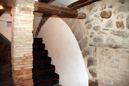 a staircase in a building with a stone wall at Casa Rural Vistes de Morella in Morella