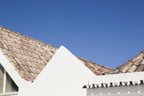 un toit d'une maison avec un ciel bleu en arrière-plan dans l'établissement A Muralha, à Tavira