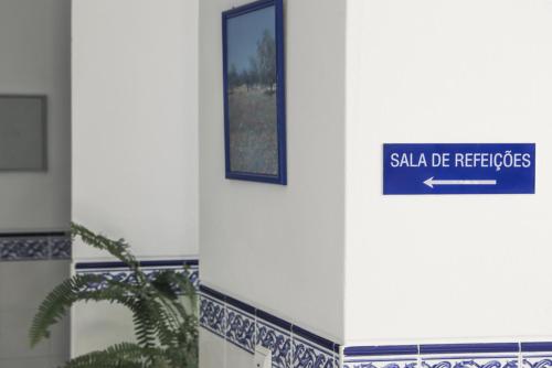 a blue sign on the side of a building at A Muralha in Tavira