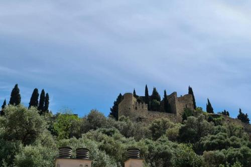 un château au sommet d'une colline avec des arbres dans l'établissement LE PITCHOUNE - Hyper centre - Climatisation, à Cassis