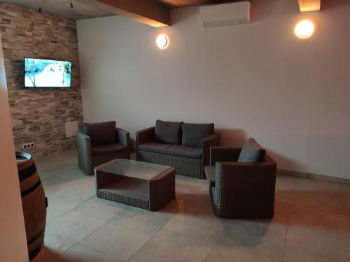 a living room with couches and a tv on a wall at LE CHARME D OGNES in Ognes