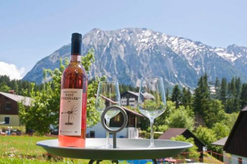 a bottle of wine and two wine glasses on a table at Appartement Grimminggarten in Tauplitz
