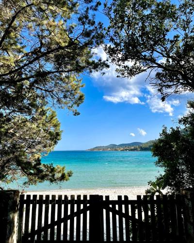 a view of a beach with a fence and the ocean at Residence Canella in Sari Solenzara