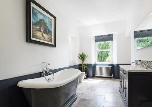 a bathroom with a white tub and a sink at Croft Na Coille in Pitlochry