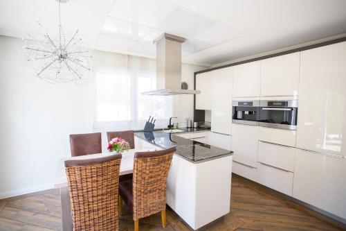 a kitchen with white cabinets and a table with chairs at Villa Vivaldi in Kühlungsborn