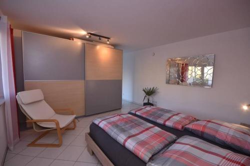 1 dormitorio con 2 camas, silla y espejo en Ferienwohnung Gartenblick an der Mainschleife en Schwarzach am Main